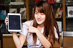 Portrait Of Thai Adult Student University Uniform Beautiful Girl Using Her Tablet Stock Photo