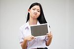 Portrait Of Thai High School Student Uniform Beautiful Girl Using Her Tablet Stock Photo