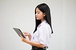 Portrait Of Thai High School Student Uniform Beautiful Girl Using Her Tablet Stock Photo