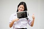 Portrait Of Thai High School Student Uniform Beautiful Girl Using Her Tablet Stock Photo