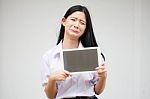 Portrait Of Thai High School Student Uniform Beautiful Girl Using Her Tablet Stock Photo