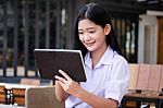 Portrait Of Thai High School Student Uniform Beautiful Girl Using Her Tablet Stock Photo