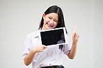 Portrait Of Thai High School Student Uniform Beautiful Girl Using Her Tablet Stock Photo