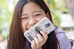 Portrait Of Thai High School Student Uniform Teen Beautiful Girl Using Her Phone And Smile Stock Photo