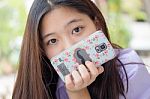 Portrait Of Thai High School Student Uniform Teen Beautiful Girl Using Her Phone And Smile Stock Photo