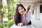 Portrait Of Thai High School Student Uniform Teen Beautiful Girl Using Her Phone And Smile Stock Photo