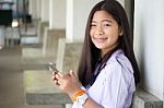 Portrait Of Thai Student Teen Beautiful Girl Using Her Phone And Smile Stock Photo