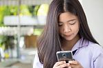 Portrait Of Thai Student Teen Beautiful Girl Using Her Phone And Smile Stock Photo