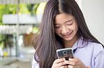 Portrait Of Thai Student Teen Beautiful Girl Using Her Phone And Smile Stock Photo