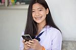 Portrait Of Thai Student Teen Beautiful Girl Using Her Phone And Smile Stock Photo