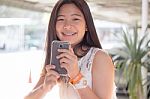 Portrait Of Thai Student Teen Beautiful Girl Using Her Phone And Smile Stock Photo