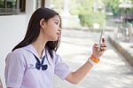 Portrait Of Thai Student Teen Beautiful Girl Using Her Phone And Smile Stock Photo