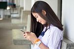 Portrait Of Thai Student Teen Beautiful Girl Using Her Phone And Smile Stock Photo