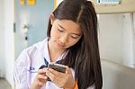 Portrait Of Thai Student Teen Beautiful Girl Using Her Phone And Smile Stock Photo