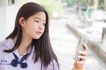 Portrait Of Thai Student Teen Beautiful Girl Using Her Phone And Smile Stock Photo