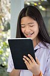 Portrait Of Thai Student Teen Beautiful Girl Using Her Tablet Stock Photo