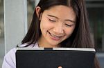 Portrait Of Thai Student Teen Beautiful Girl Using Her Tablet Stock Photo