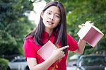 Portrait Of Thai Teen Beautiful Girl In Chinese Dress, Happy New Year And Open Box Gift, Smile And Very Happy Stock Photo