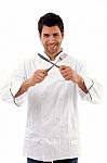 Portrait Of Young Male Chef Holding Fork And Knife Stock Photo