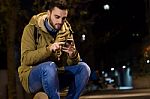 Portrait Of Young Man Using His Mobile Phone On The Street At Ni Stock Photo