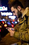 Portrait Of Young Man Using His Mobile Phone On The Street At Ni Stock Photo