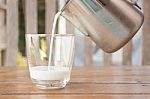 Pour Milk From A Pitcher Into A Glass Stock Photo