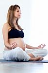 Pregnant Woman Relax Doing Yoga, Sitting In Lotus Position Stock Photo