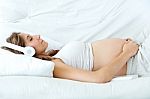 Pregnant Woman Sitting On Sofa At Home And Listening Music In He Stock Photo