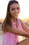 Pretty Girl Sitting On The Roof At Sunset Stock Photo