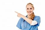 Pretty Lady Doctor Pointing Away Stock Photo