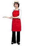 Pretty Model In Bakers Apron Presenting Stock Photo