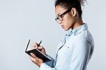 Pretty Young Black Woman Taking Notes At Home Stock Photo