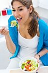 Pretty Young Woman Eating Salad At Home Stock Photo