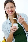 Pretty Young Woman Eating Yogurt In The Kitchen Stock Photo