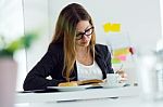 Pretty Young Woman Reading A Book And Having Breakfast At Home Stock Photo