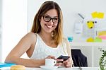 Pretty Young Woman Using Her Mobile Phone At Home Stock Photo