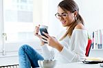 Pretty Young Woman Using Her Mobile Phone In The Office Stock Photo