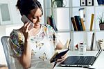 Pretty Young Woman Using Her Mobile Phone In The Office Stock Photo