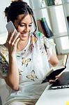 Pretty Young Woman Using Her Mobile Phone In The Office Stock Photo