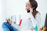 Pretty Young Woman Using Her Mobile Phone In The Office Stock Photo