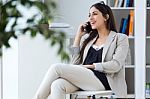 Pretty Young Woman Using Her Mobile Phone In The Office Stock Photo