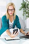 Pretty Young Woman Working And Using Her Mobile Phone Stock Photo