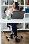 Pretty Young Woman Working With Laptop In Her Office Stock Photo