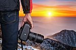 Professional Photographer With Camera At Sunset Stock Photo