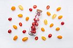 Red And Yellow Cherry Tomatoes On A White Background Stock Photo