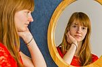 Redhead Teenage Girl Looking In Mirror Stock Photo