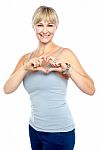 Romantic Middle Aged Woman Gesturing Heart Shape Stock Photo