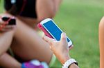 Running Girls Having Fun In The Park With Mobile Phone Stock Photo