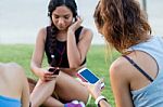 Running Girls Having Fun In The Park With Mobile Phone Stock Photo