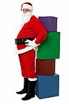 Santa Standing Beside Pile Of Xmas Gifts Stock Photo